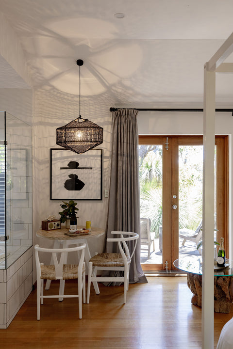 Modern interior with a dining area, light fixture, and large window.