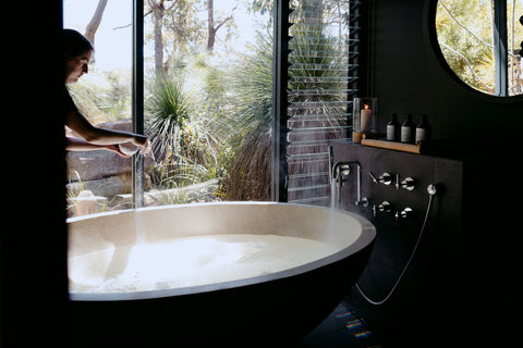 Spa room with a large oval bathtub near a window with a natural view