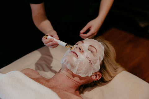 Person receiving a facial treatment with a mask on their face.