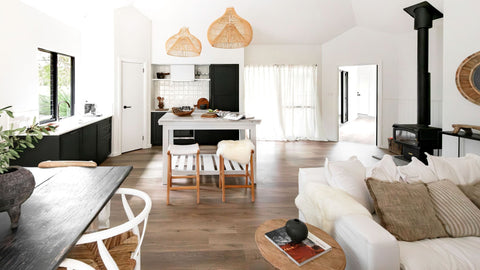 Modern living room with white furniture, wooden floor, and decorative elements.