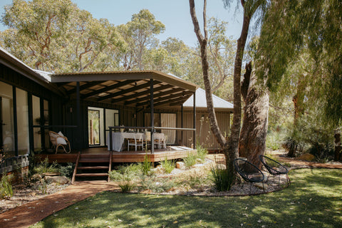 Luxury cabin in a bushland with a wooden deck and outdoor furniture