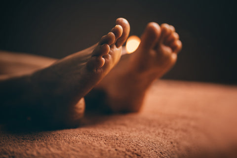 Close-up of feet on a textured surface with warm lighting