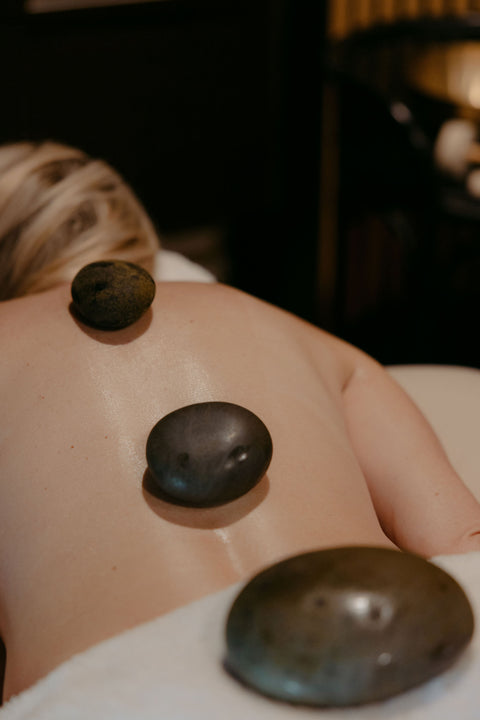 Person receiving a hot stone massage with blurred background