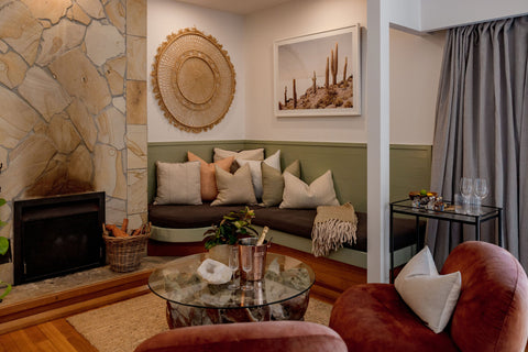Living room with stone fireplace, sofa, and armchair.