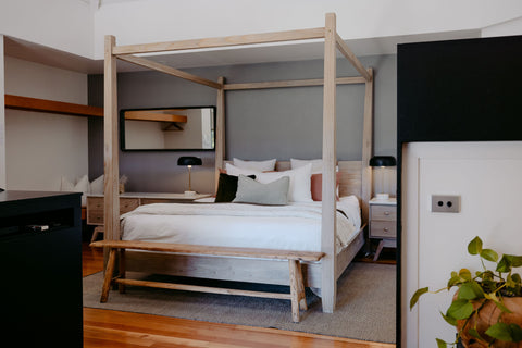 Bedroom with a wooden four-poster bed and modern decor.