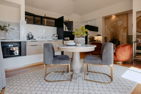 Modern kitchen and dining area with marble table and chairs.